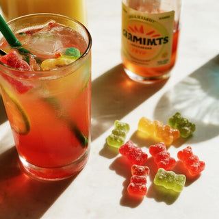 Colorful cortisol cocktail and gummy bears on a lively tabletop, evoking a dopamine-boosting vibe with vibrant, stress-relief imagery.