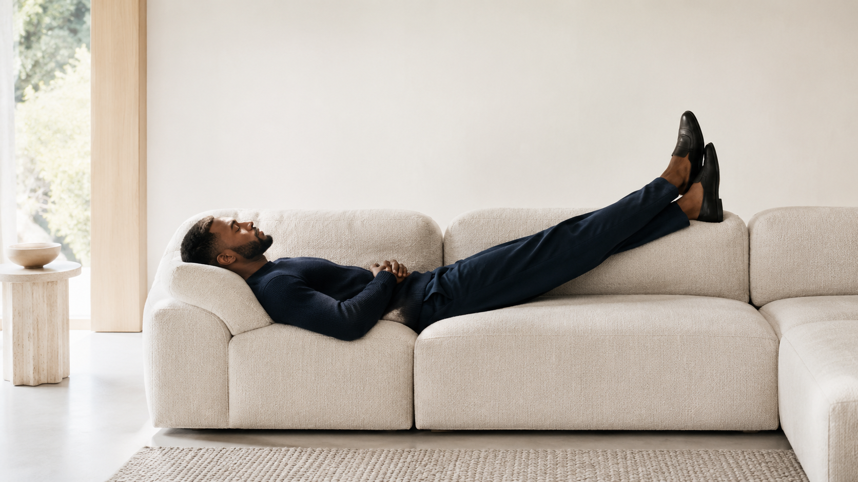 A young man unwinding on a cozy sofa, mindfully holding a bottle of Greenpeople Ashwagandha supplements.